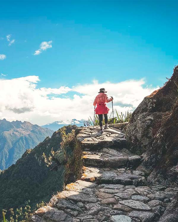 Woman hiking the incredible ancient Inca Trail to Machu Picchu near the cliff